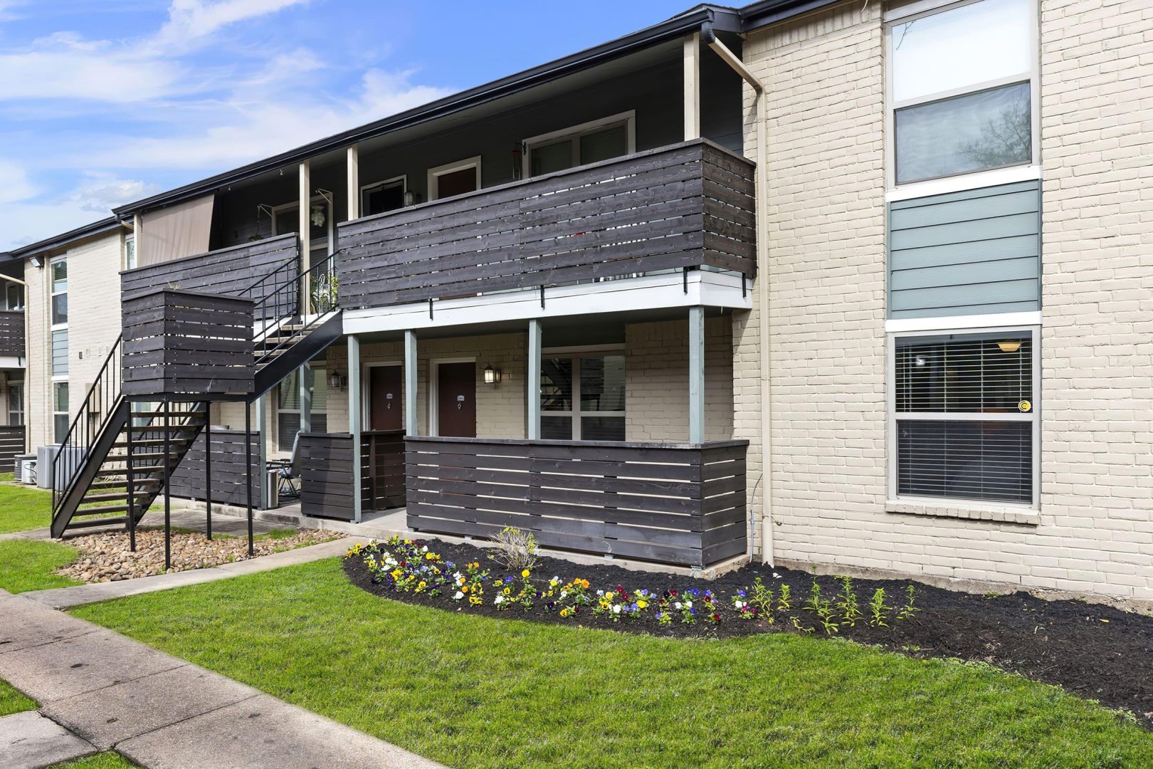 the exterior of an apartment building with stairs and a balcony at The  Adelene